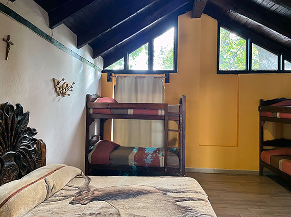 Interior de cabaña para 6 personas con cama matrimonial y dos literas en el Centro Turístico Angahuan