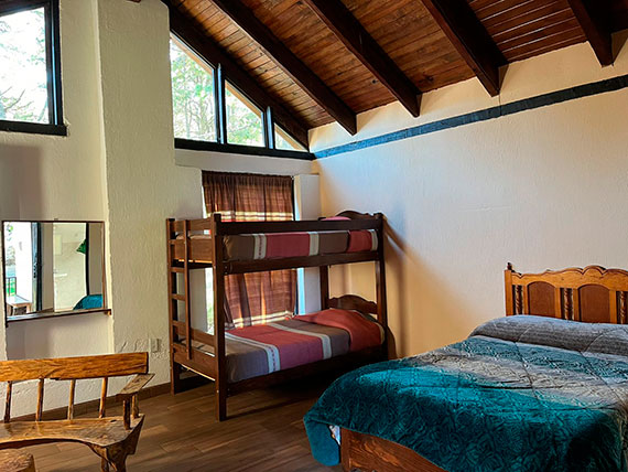 Vista lateral de cabaña para 4 personas con cama matrimonial y litera, Centro Turístico Angahuan